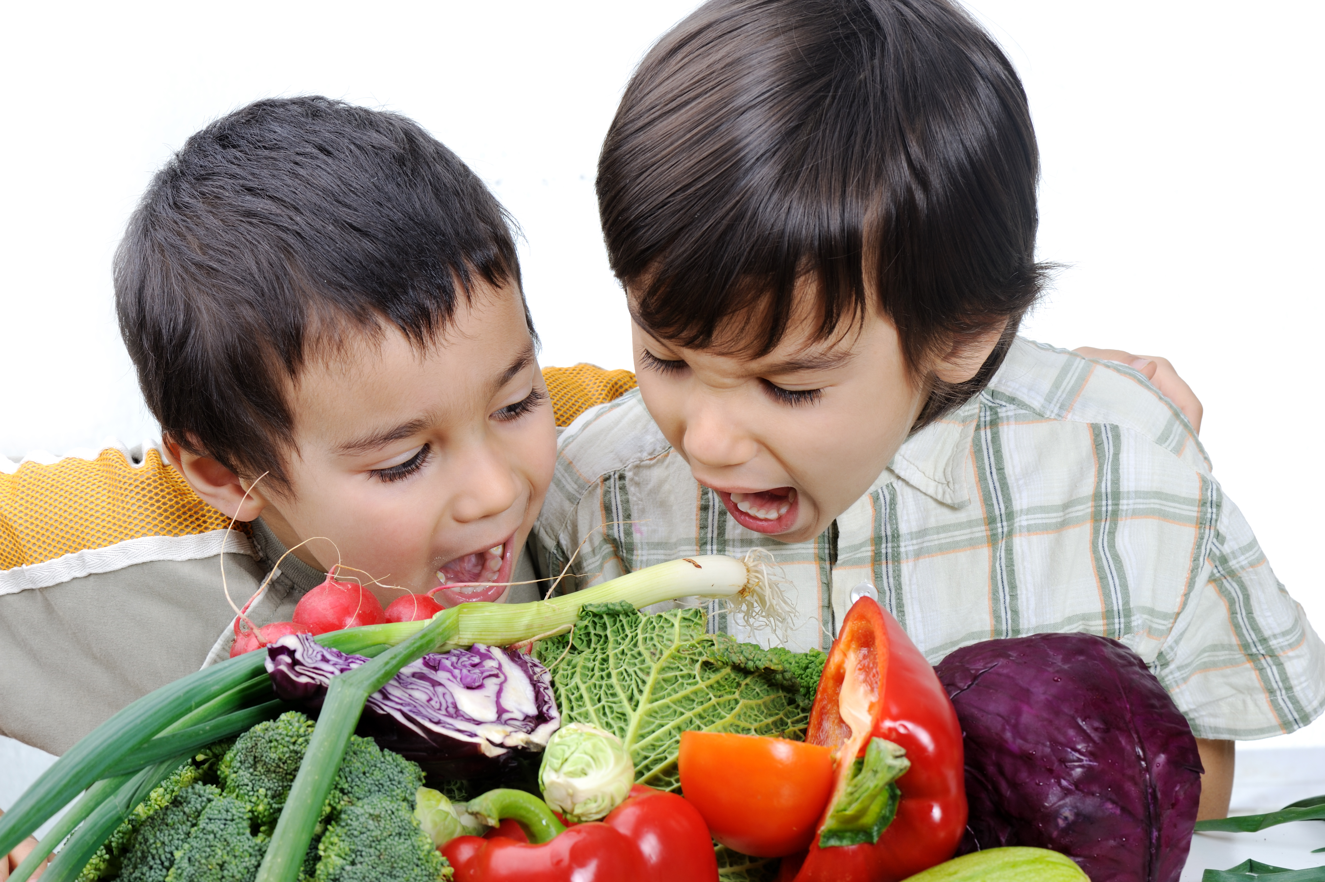 two boys eating veggies