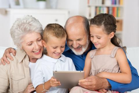 Seniors looking at technology with grankids