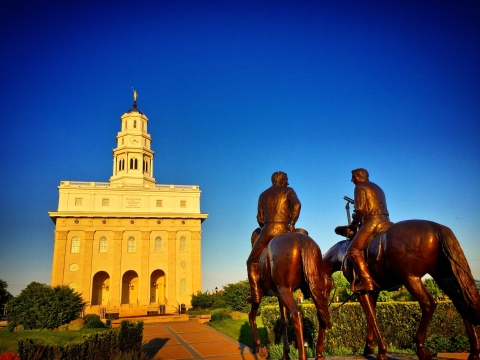 Statues of horse riders in front of a historic building