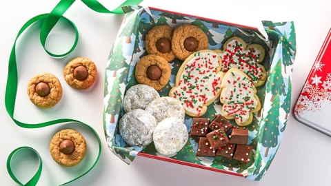 A variety of holiday cookies in a green box